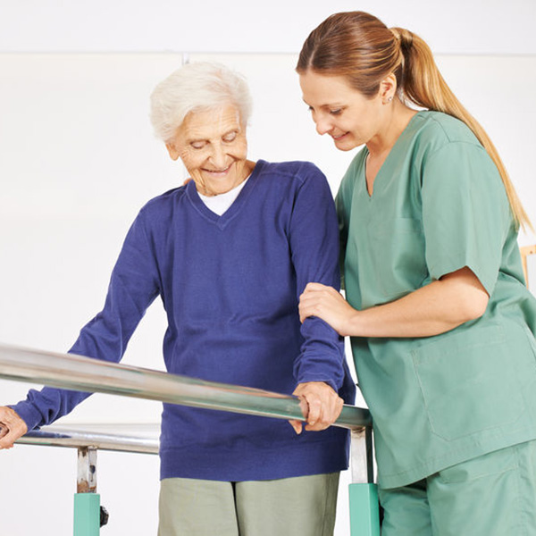 Physiotherapist helps senior woman on treadmill